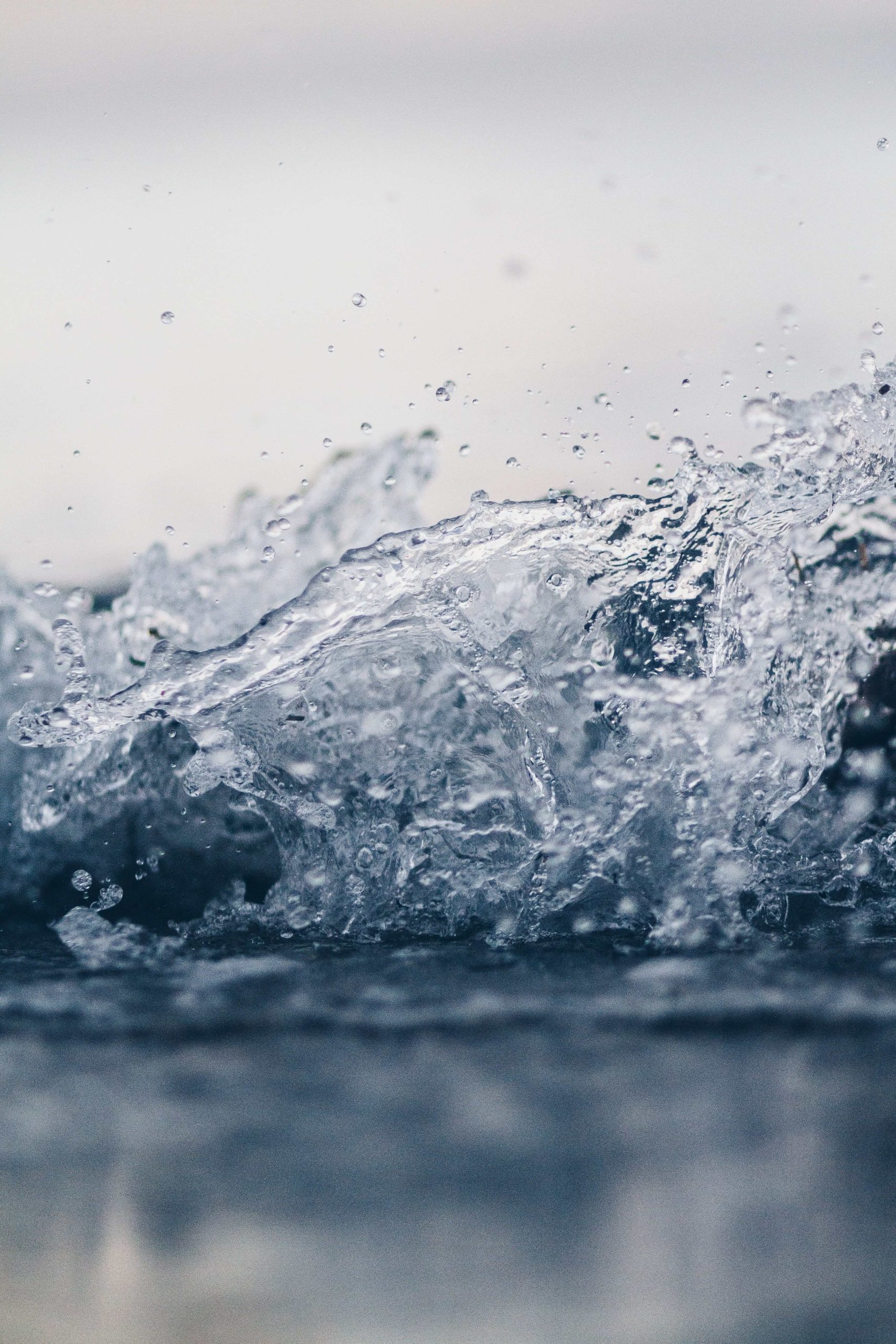 A wave of water breaking and throwing up spray.