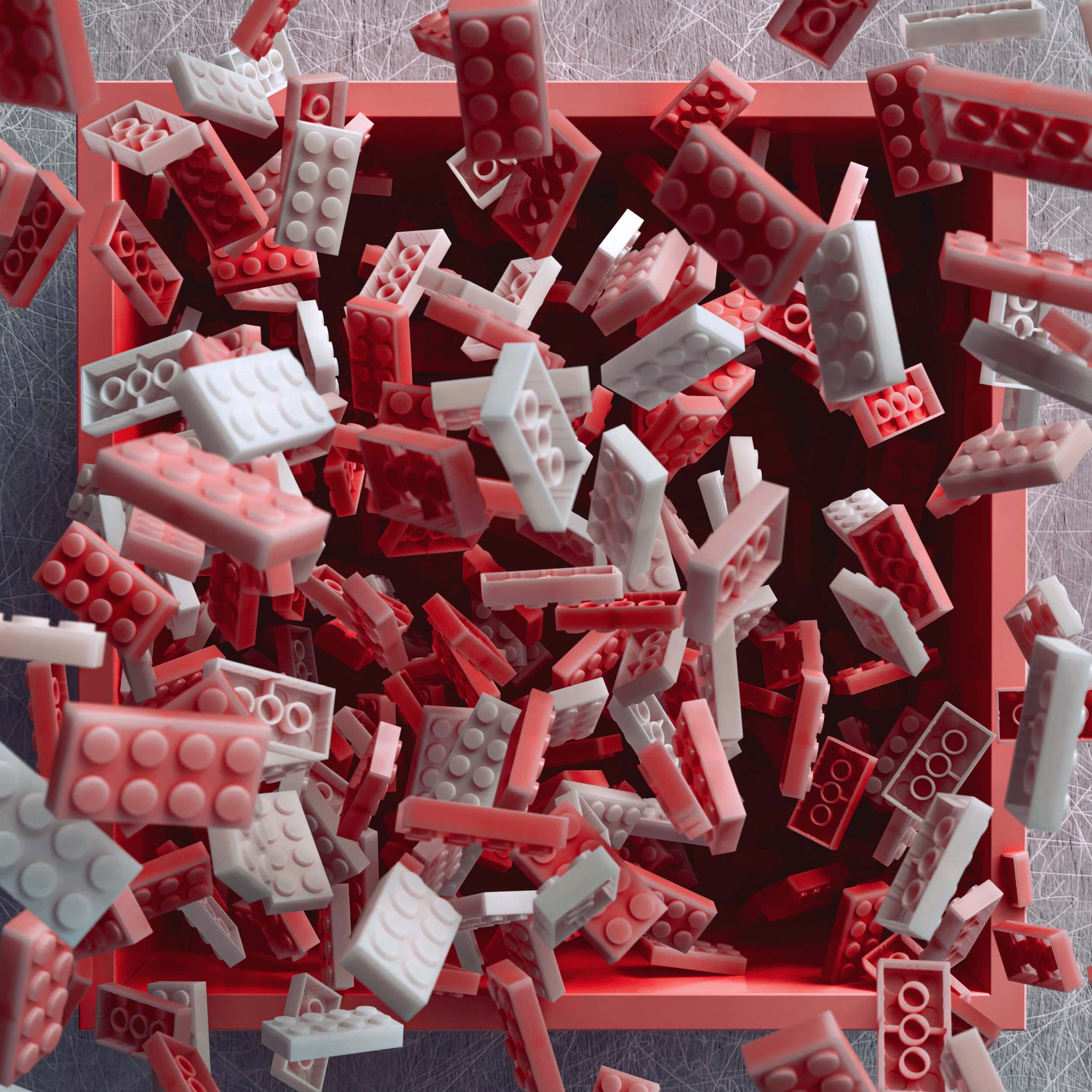 A shallow red tray filled with scattered red and white building bricks.